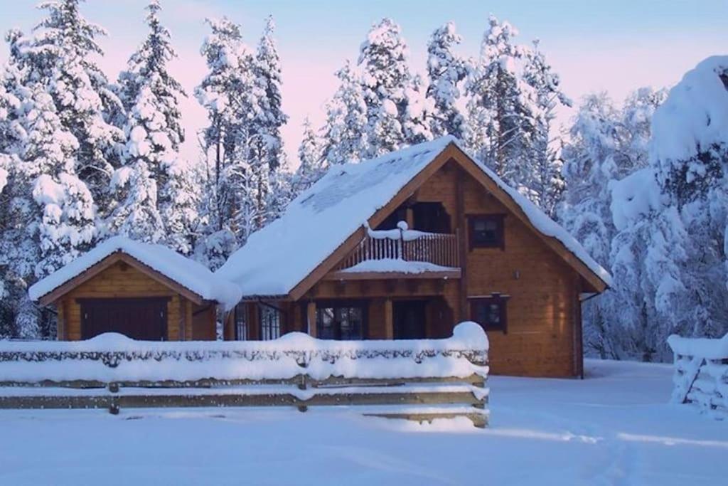 une cabane en rondins avec de la neige sur le toit dans l'établissement Norwegian Log Cabin The Roe Deer -sauna & hot tub, à Keith