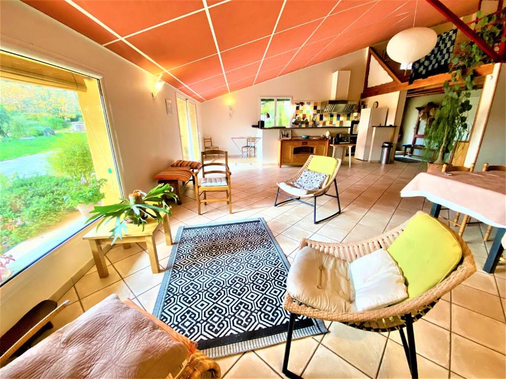a large living room with chairs and a table at CHAMBRES D&#39;HOTES 2 à 4p ou GITE DE GROUPE 15p, 7 ch, 6 sdb, parc et salle de réception in Villeneuve-de-Berg