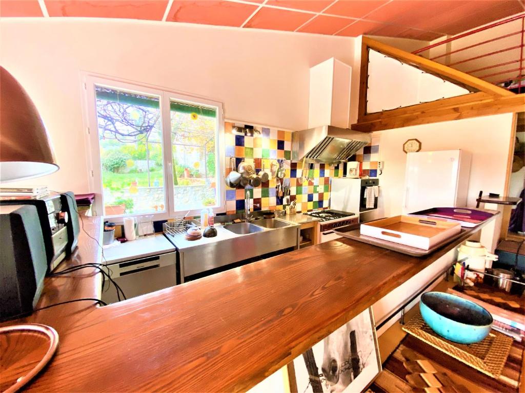 a kitchen with a wooden counter top in a room at CHAMBRES D&#39;HOTES 2 à 4p ou GITE DE GROUPE 15p, 7 ch, 6 sdb, parc et salle de réception in Villeneuve-de-Berg