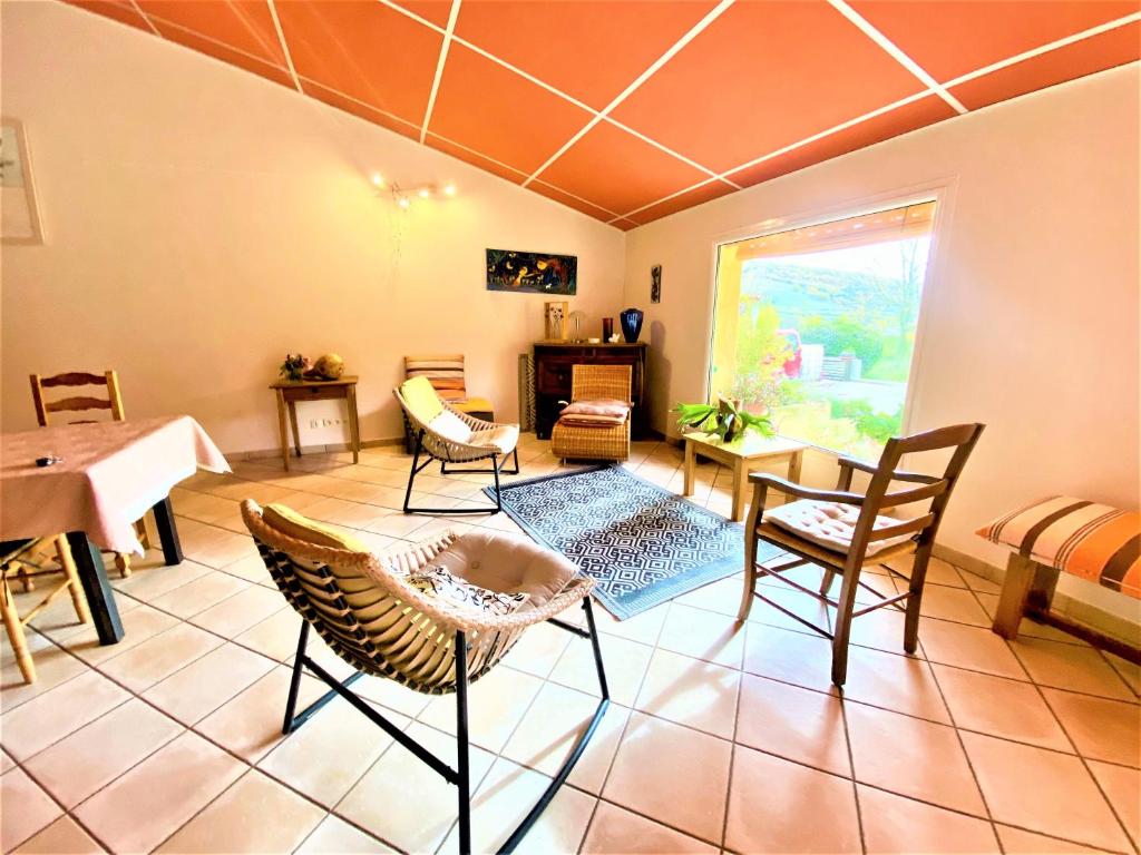 a living room with a table and chairs at CHAMBRES D&#39;HOTES 2 à 4p ou GITE DE GROUPE 15p, 7 ch, 6 sdb, parc et salle de réception in Villeneuve-de-Berg