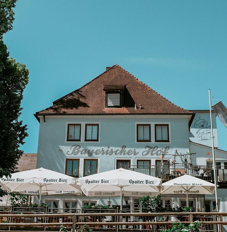 a large white building with umbrellas in front of it at Bayerischer Hof Spalt in Spalt