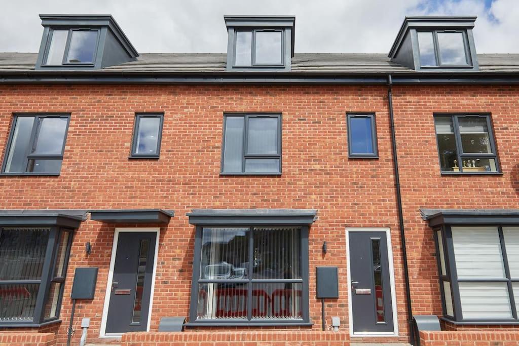 uma casa de tijolos vermelhos com janelas pretas em Urban Bliss, Park with Ease 3 Bed New Build Home em Leicester