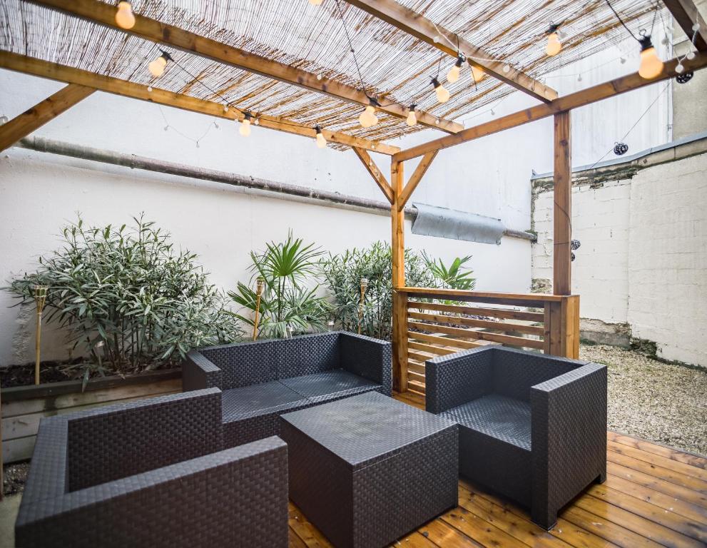 a patio with tables and chairs under a pergola at L&#39;Art du Temps - Terrasse -1 min Hypercentre in Troyes