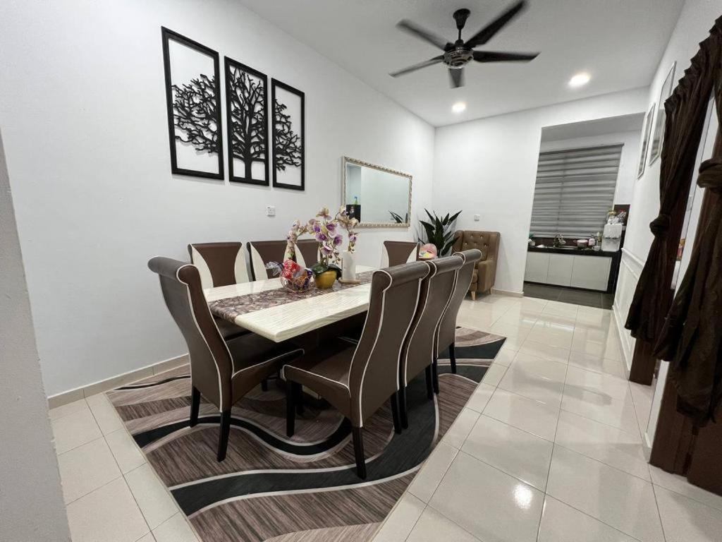 a dining room with a table and chairs at Homestay Kemaman Fyna06 in Kemaman