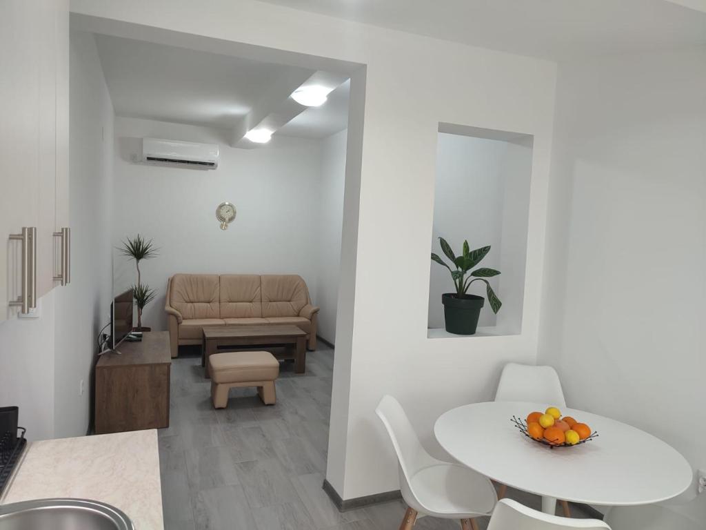 una sala de estar blanca con mesa y sillas en Ana Belgrade Apartments, en Belgrado