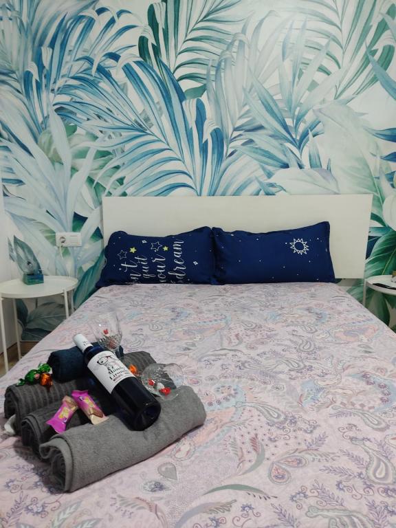 ein Bett mit einer Flasche Wein drauf in der Unterkunft Habitación cactus, entrada privada y baño privado en suite by flamingo house, no fumadores in Arrecife