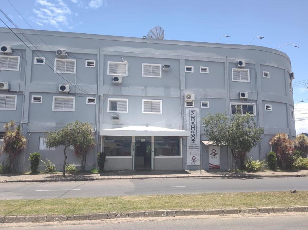 un gran edificio gris con árboles delante de él en RUBY HOSPEDAGENS, en Indaiatuba