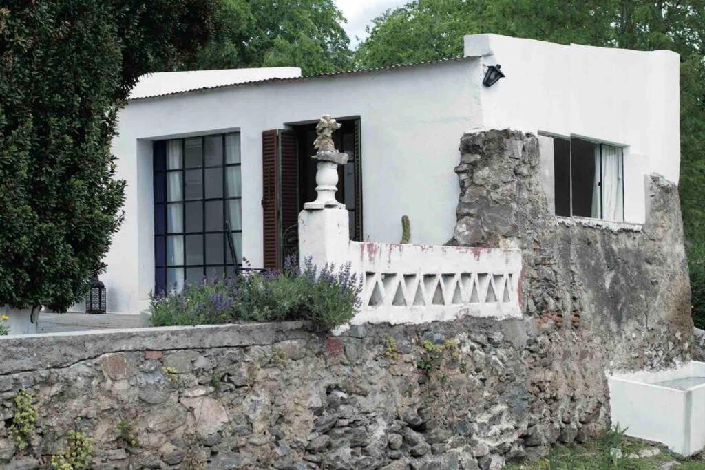a white house behind a stone wall at Andaluzia Casa Hotel in Villa Tulumba
