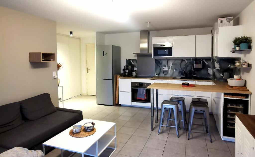 sala de estar con sofá y cocina en Capbreton Superbe appartement avec parking en Capbreton