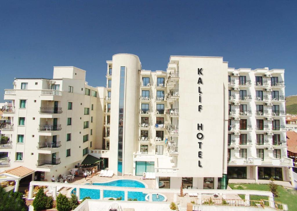 a hotel with a swimming pool in front of two buildings at Kalif Hotel in Ayvalık