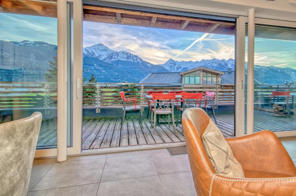 een kamer met een balkon met een tafel en stoelen bij Penthouse Ski & Golf - by Alpen Apartments in Zell am See