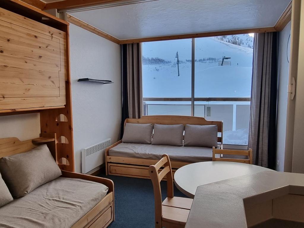 un salon avec un canapé et une table dans l'établissement Studio Divisible Ski aux Pieds avec Balcon à Aime 2000 - FR-1-181-2619, à Aime La Plagne