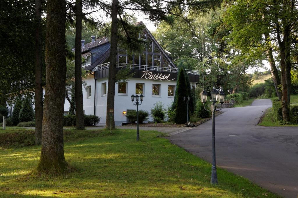 ein weißes Haus mit einem Schild an der Straßenseite in der Unterkunft Waldhotel Wilhelmshöhe in Freudenberg