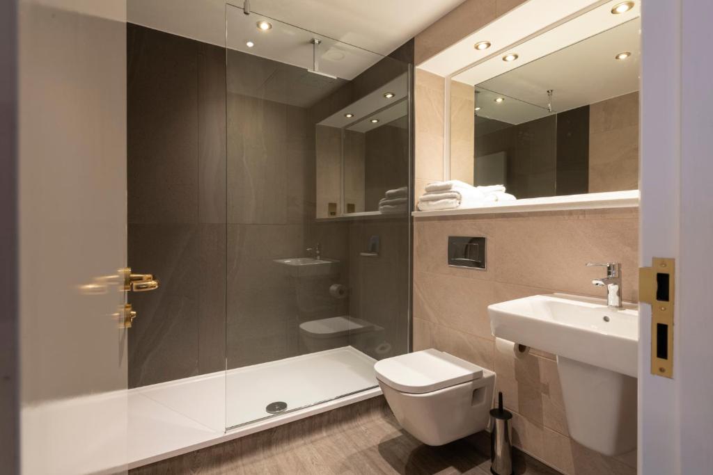 a bathroom with a shower and a toilet and a sink at The Saxon Crown Wetherspoon in Corby