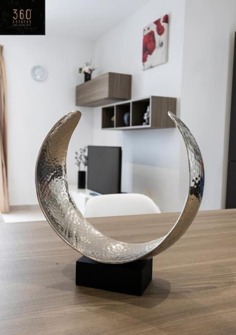 a metal sculpture of a crescent moon on a floor at Spacious, beautiful central penthouse with BBQ by 360 Estates in Tal-Pietà