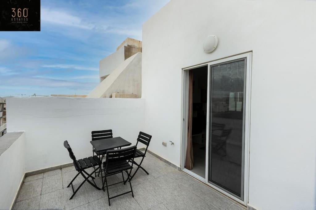 a patio with a table and chairs on a balcony at Spacious, beautiful central penthouse with BBQ by 360 Estates in Tal-Pietà