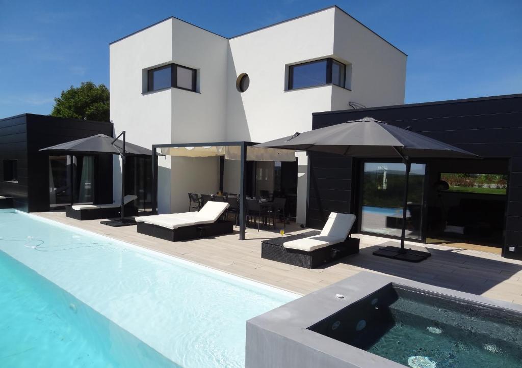 een huis met een zwembad naast een gebouw bij Luxueuse propriété SAINT CIRICE aux vues aériennes in Cahors