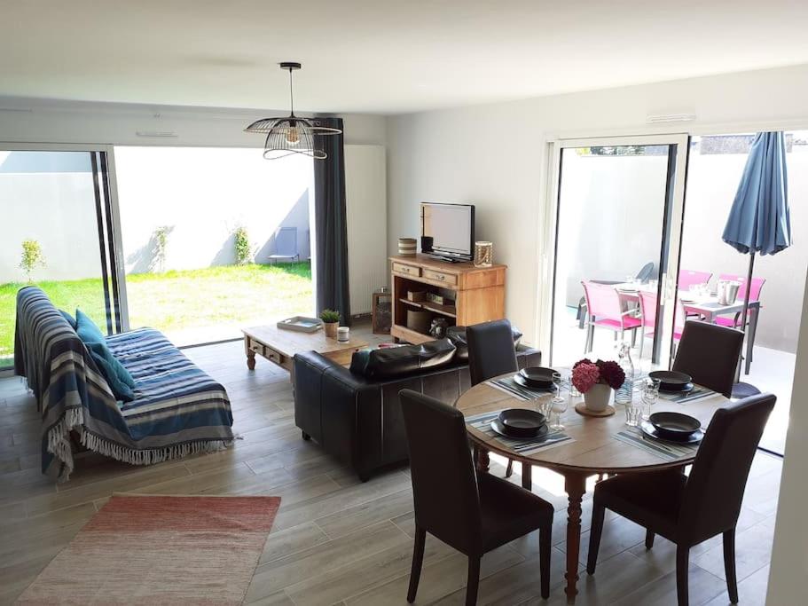 uma sala de estar com uma mesa e um sofá em Maison au Moustoir-Arradon à 200 m du Golfe em Arradon