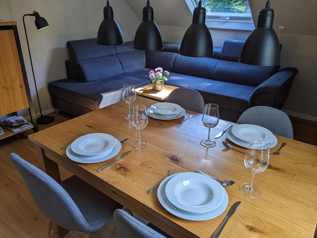 einen Esstisch mit Tellern und Weingläsern in der Unterkunft Schmugglernest in Monschau