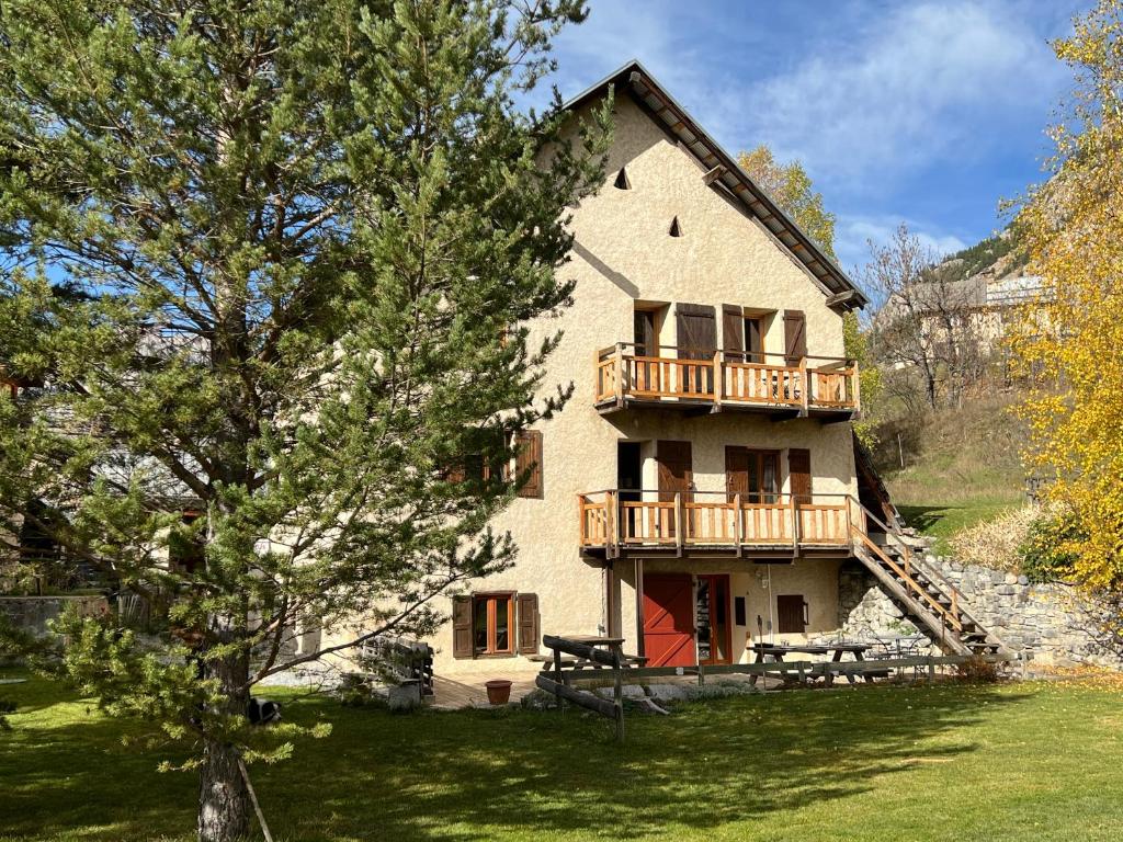 een groot huis met een balkon aan de zijkant bij Inspiration Montagne Chambre d'hôtes in Névache