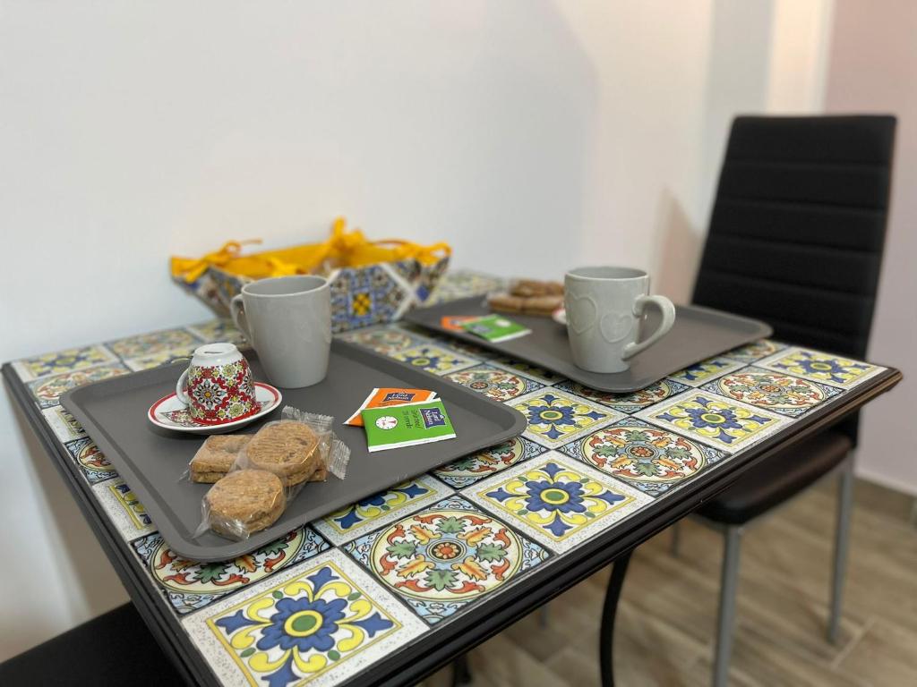 a table with two plates of food and two cups at A boné Guest house in Catania