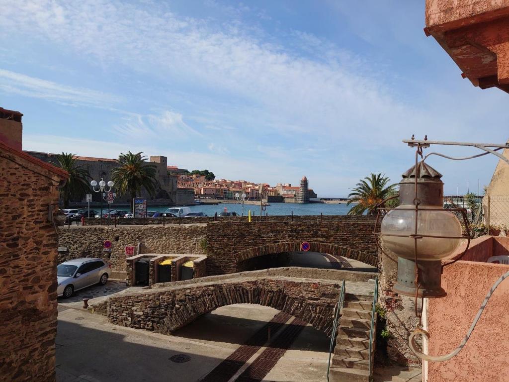 un pont en pierre sur une route à côté d'une masse d'eau dans l'établissement 5COMA2 Appartement proche plage, à Collioure