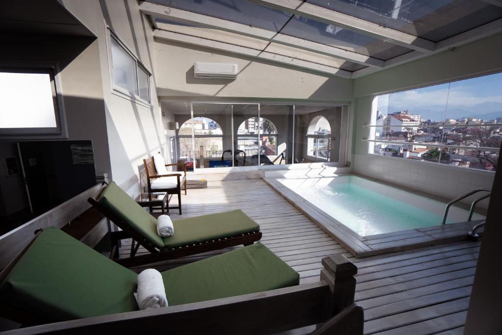 Habitación con piscina, sillas y ventana grande. en Hotel Almería en Salta