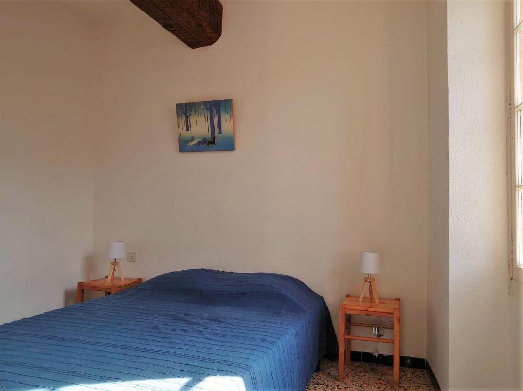 a bedroom with a blue bed and two tables at 5COMA2 Appartement proche plage in Collioure