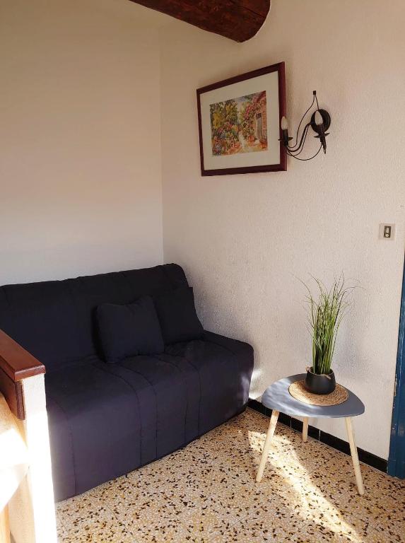a living room with a blue couch and a table at 5COMA2 Appartement proche plage in Collioure