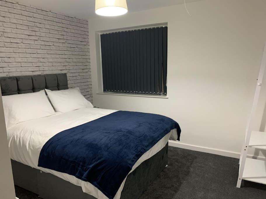 um quarto com uma cama e uma parede de tijolos em 1. Delightful Apartment em Birmingham
