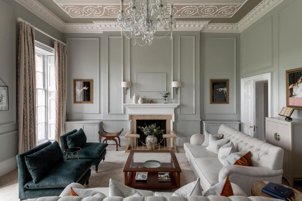 a living room with a couch and a chandelier at The Royal Crescent Hotel & Spa in Bath