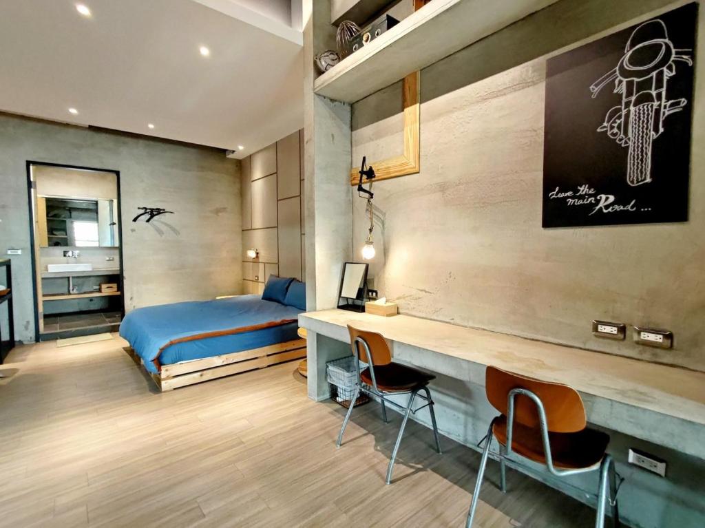 1 dormitorio con 1 cama, escritorio y sillas en 洛夫特Looft包棟民宿, en Hengchun