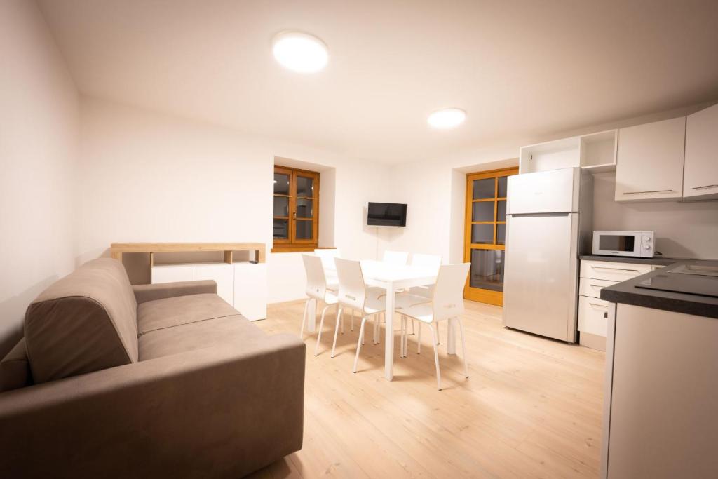 a living room with a couch and a kitchen with a table at Cesa Meida 2B in Pozza di Fassa