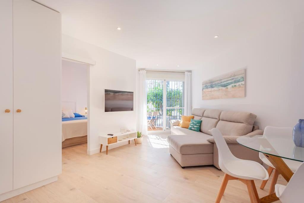 a white living room with a couch and a table at FARO PUERTO ESTEPONA in Estepona