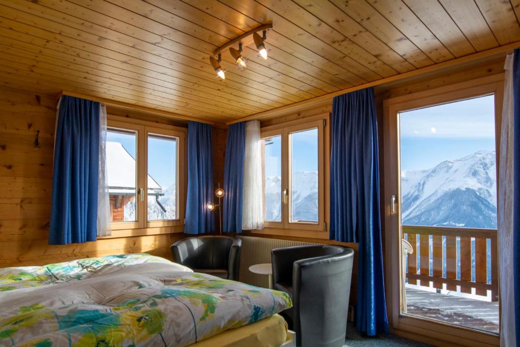 um quarto com uma cama e vista para uma montanha em Chalet Weisshorn 5 em Bettmeralp