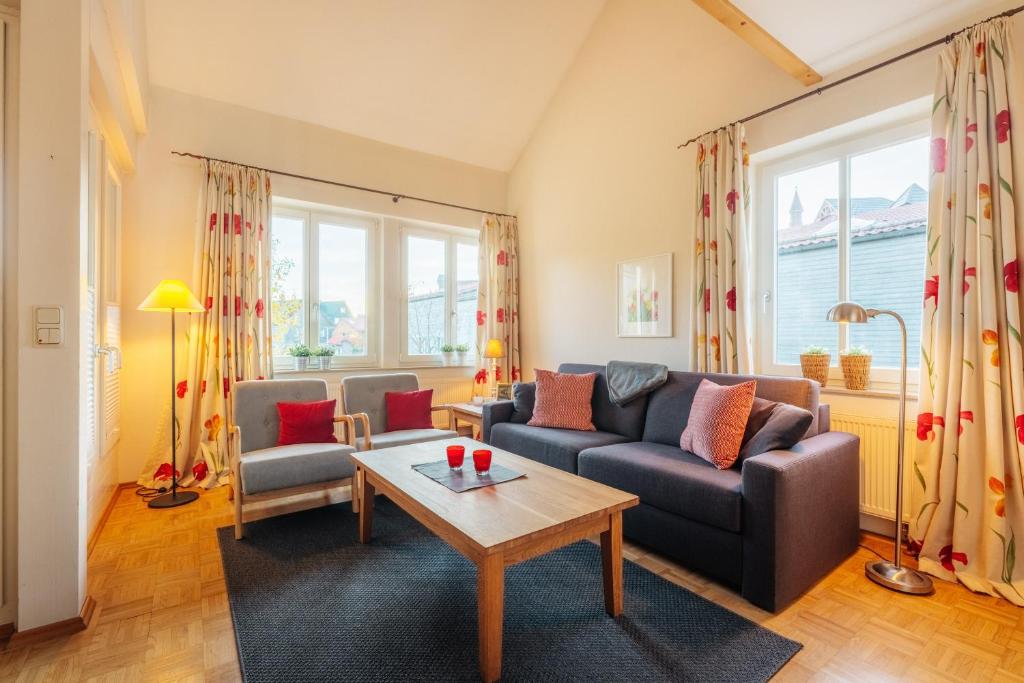 a living room with a couch and a table at Wintergartenhaus Braunlage in Braunlage