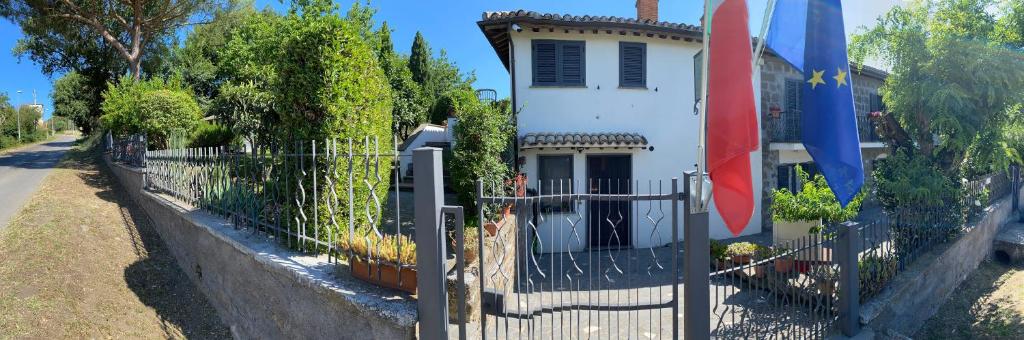 una cerca frente a una casa blanca con bandera en Alloggio Turistico La Balocca, en Montefiascone