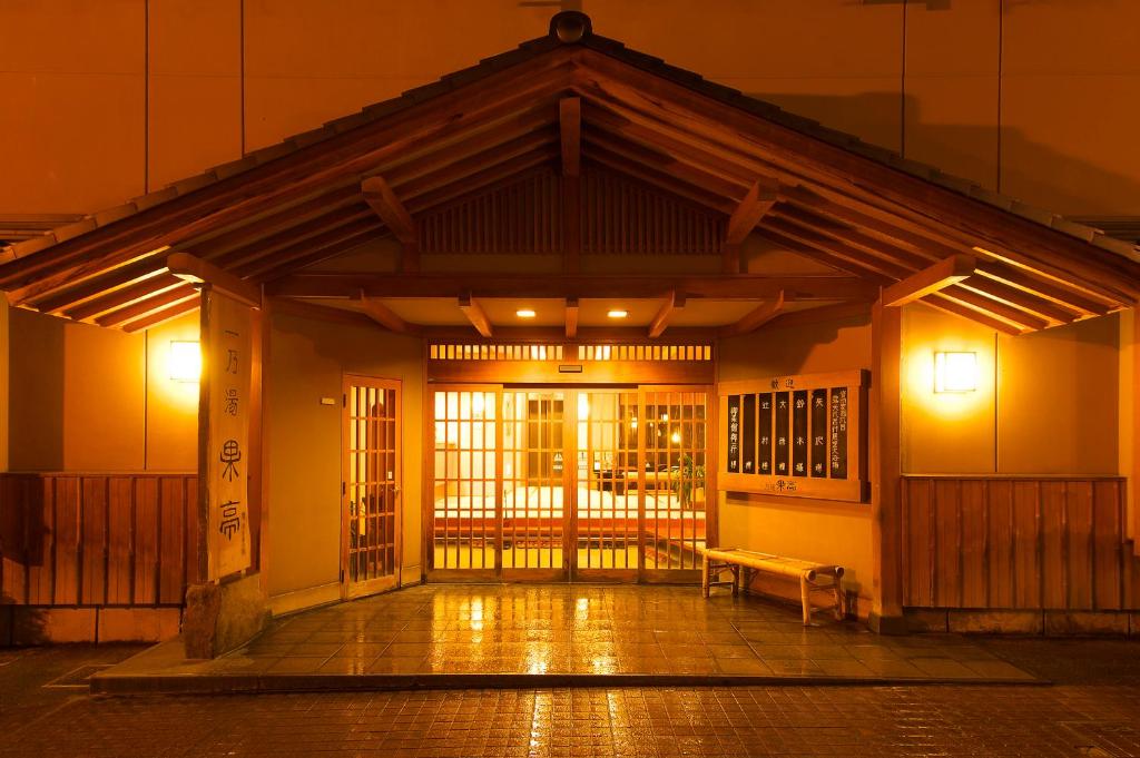 un edificio con un banco delante de él por la noche en Ichinoyu Katei, en Yamanouchi