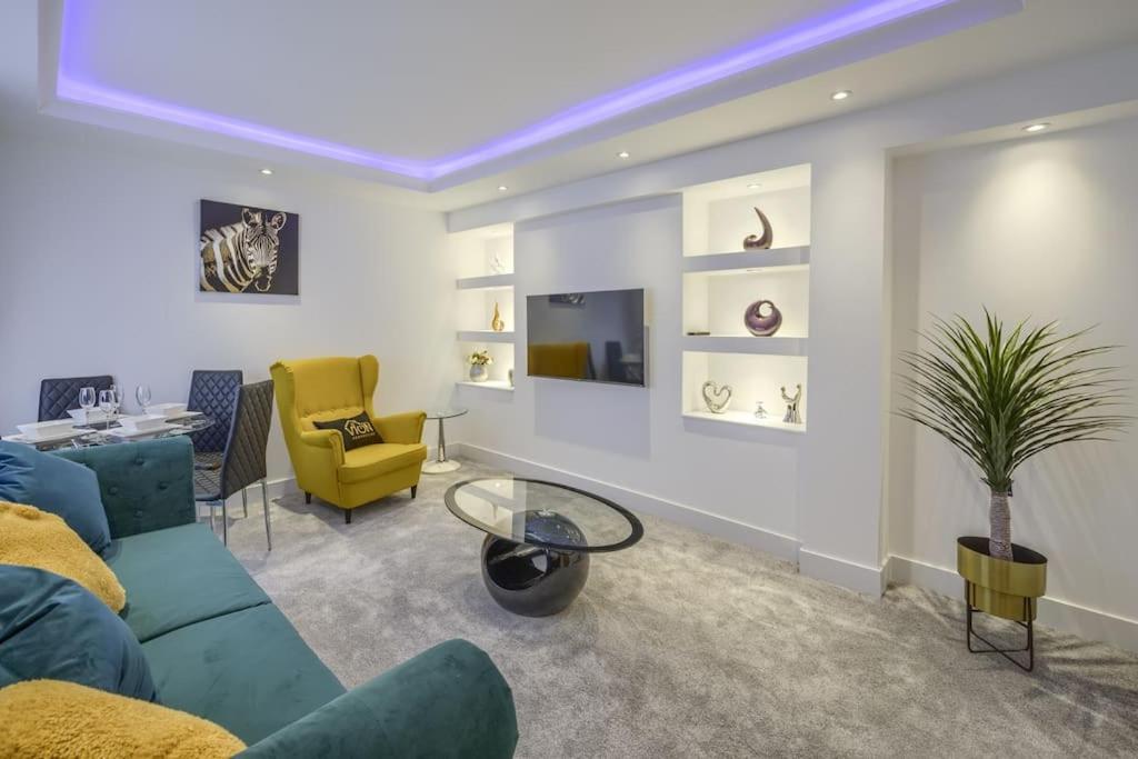 a living room with a blue couch and a yellow chair at Vion Apartment- Westerton in Aberdeen