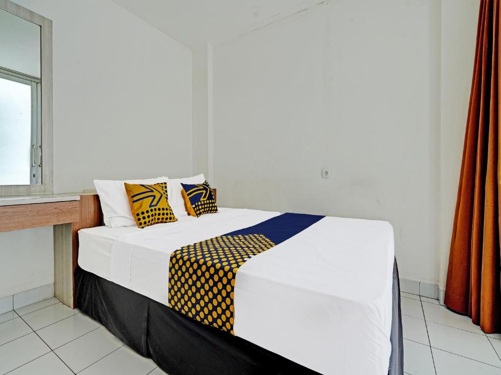 a bed with two pillows on it in a room at SUPER OYO 2190 Alamanda 7 Syariah in Bandung