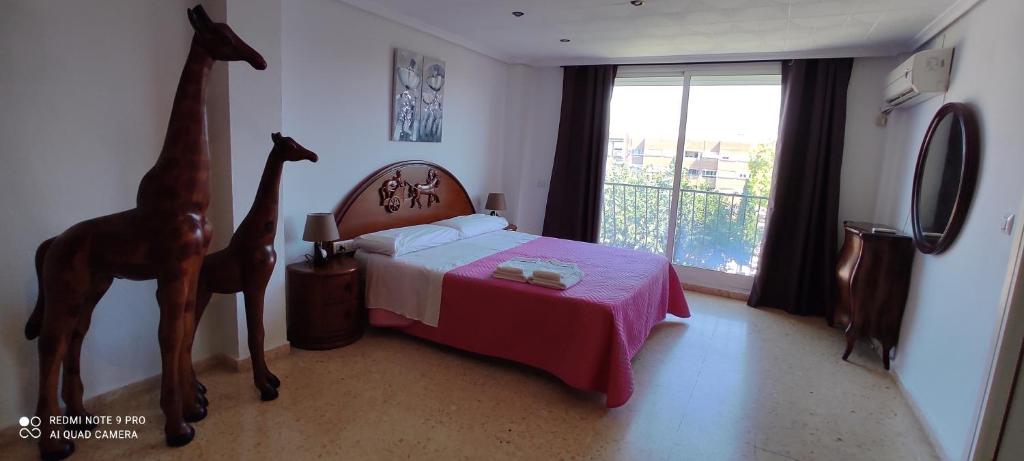 1 dormitorio con 1 cama con cabecero de jirafa y ventana en Gracioso apartamento en Massanassa, en Benetúser