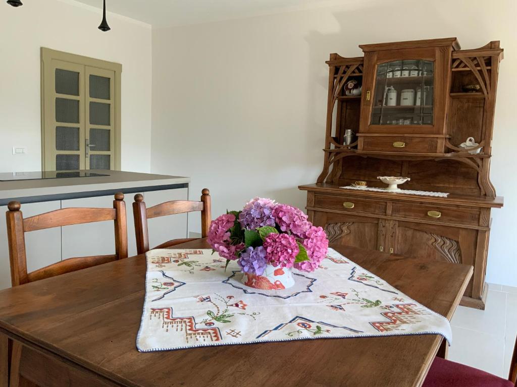 uma mesa de madeira com um vaso de flores em Appartamento Biò em Borgofranco dʼIvrea