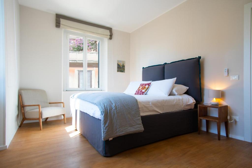 een slaapkamer met een bed, een stoel en een raam bij Aventino 2A in Rome