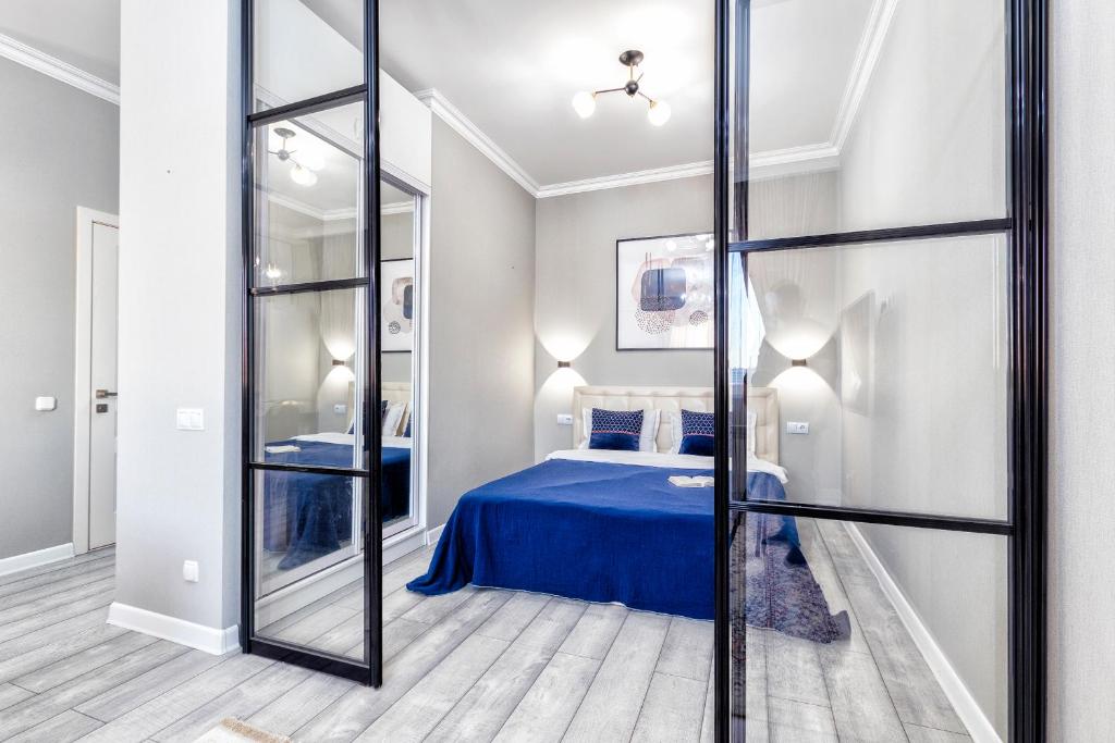 - une chambre avec un lit bleu et un miroir dans l'établissement Прекрасная квартира в центре левого берега, à Astana