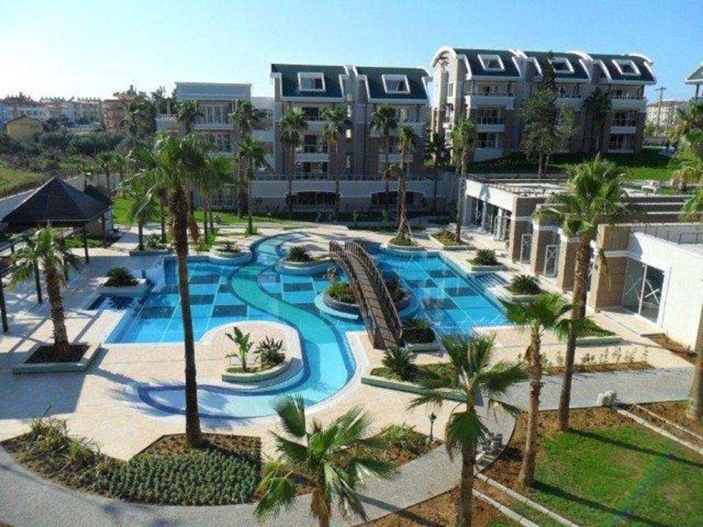 een luchtzicht op een zwembad van het resort met palmbomen bij Outstanding 3 Bed Duplex in popular gated community in Side
