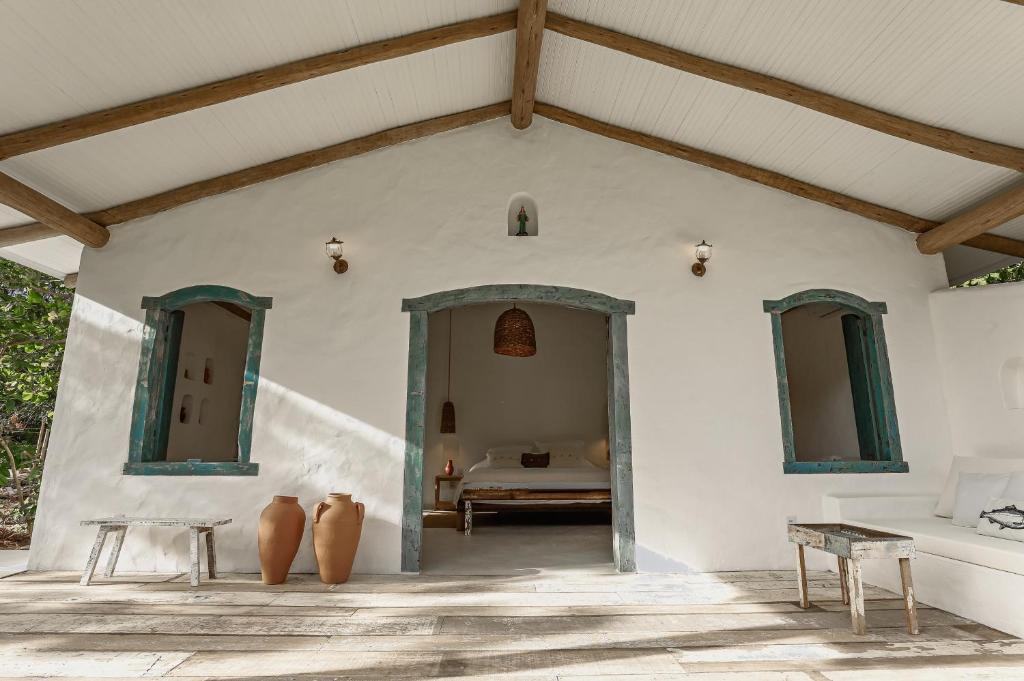 a white house with a room with a bed at Vila Oyá - praia de algodões in Marau