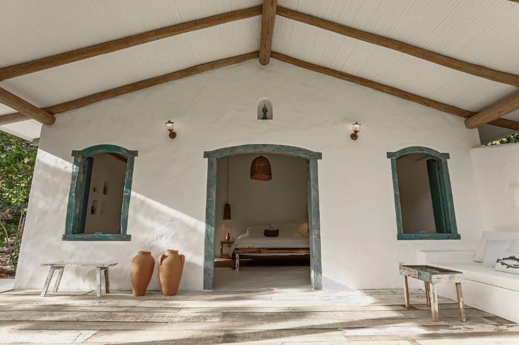 uma casa branca com um quarto com uma cama em Vila Oyá - praia de algodões em Marau