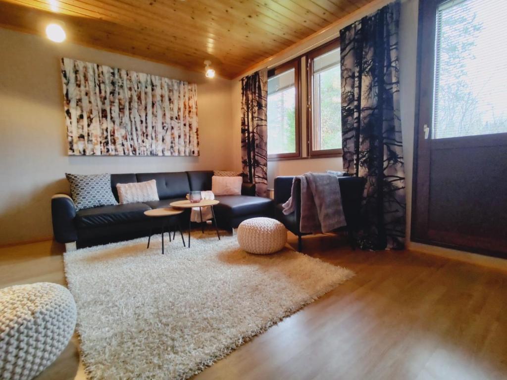 een woonkamer met een bank en een tafel bij Ruka Kierävä with ski tickets in Kuusamo