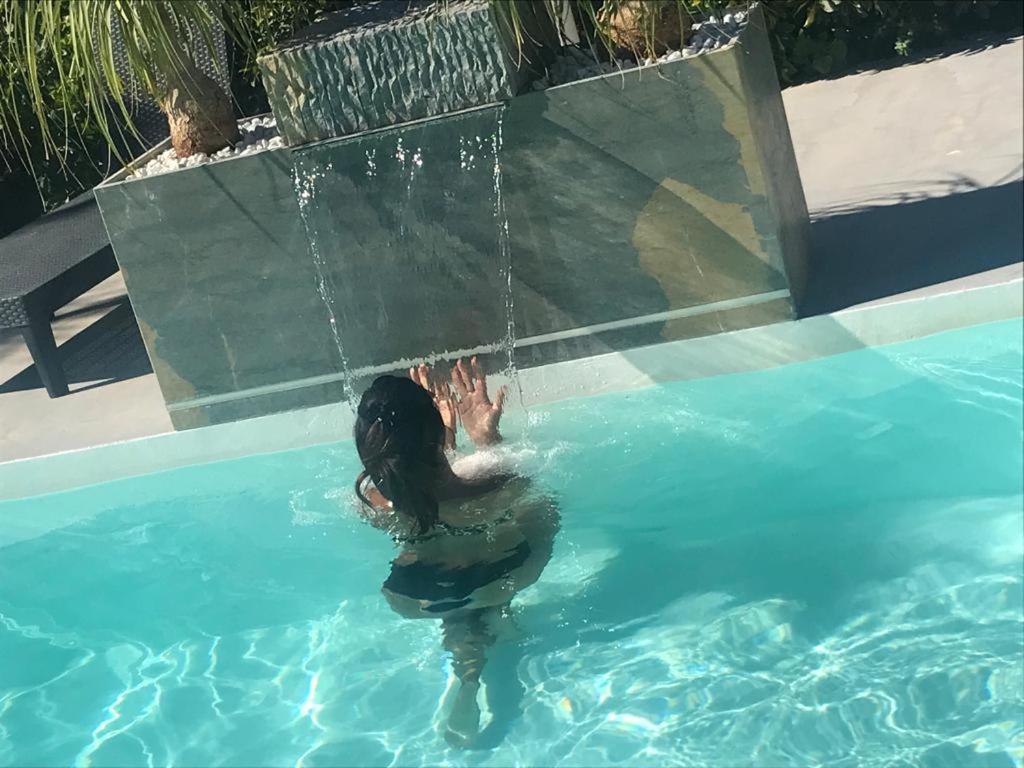 une femme est dans une piscine d'eau dans l'établissement Villa White Luxury Residence, à Marsala