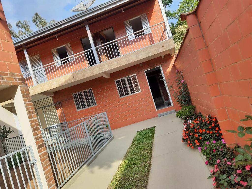 un edificio de ladrillo rojo con balcón y flores en Recanto do Zezé, en Gonçalves